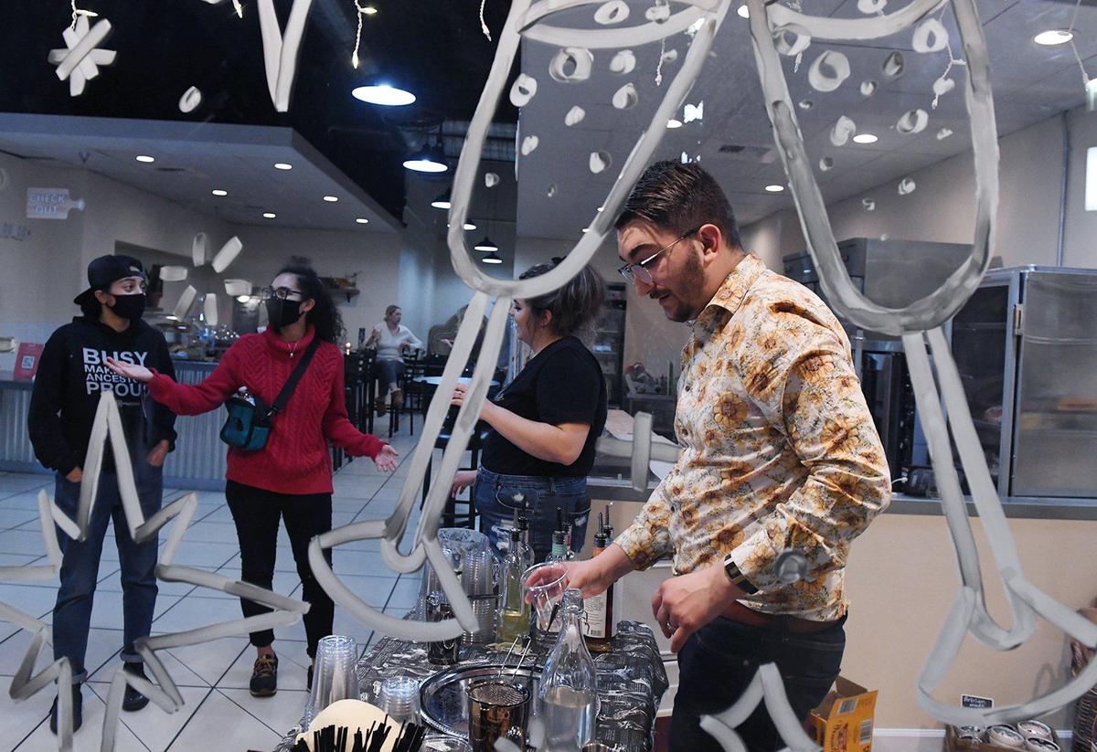 Ian Landis, right, co-owner of Bone Dry Sober Bar, makes a mocktail for customers at a pop-up event during Art Hop in 2021. The business is planning to open its own non-alcoholic bar downtown.