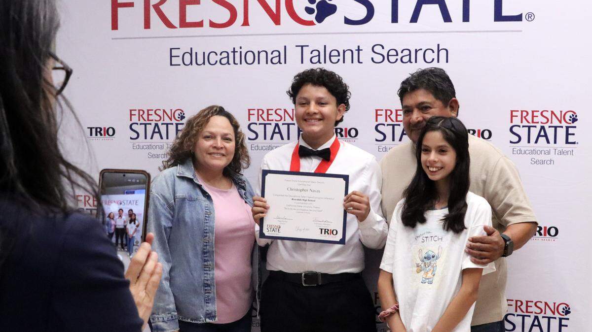 Riverdale High TRIO participant Christopher Navas, posing with his family at a program graduation on May 14, 2025, credits the program with getting him more involved in school.