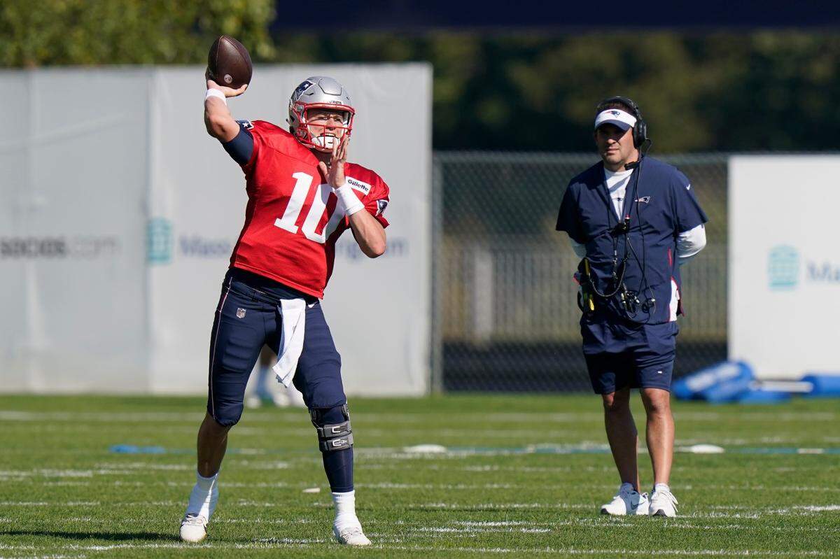 Josh McDaniels watches Mac Jones throw during a New England Patriots practice. McDaniels is the next Las Vegas Raiders head coach.