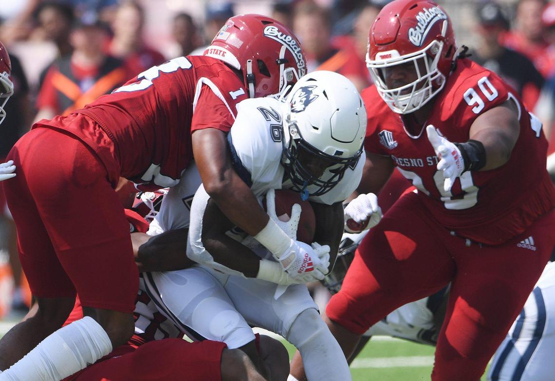 Fresno State’s defense shuts down UConn running back Nathan Carter, center, Saturday, Aug. 28, 2021, in Fresno. The Bulldogs led 31-0 at halftime.