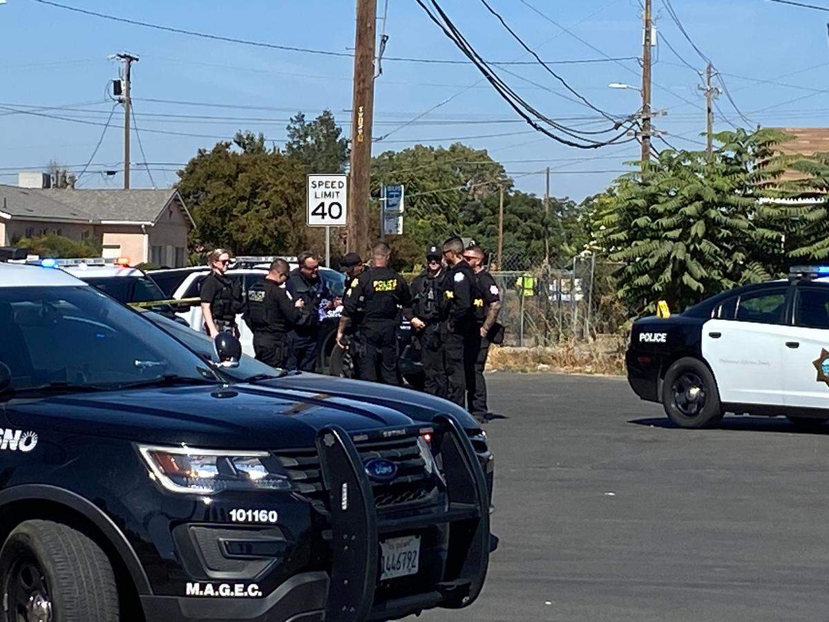 Fresno police overlook the scene where a shooter fired a suspected 23 rounds outside a convenience store, striking one man in the chest on Thursday, Oct. 12, 2023, police said.