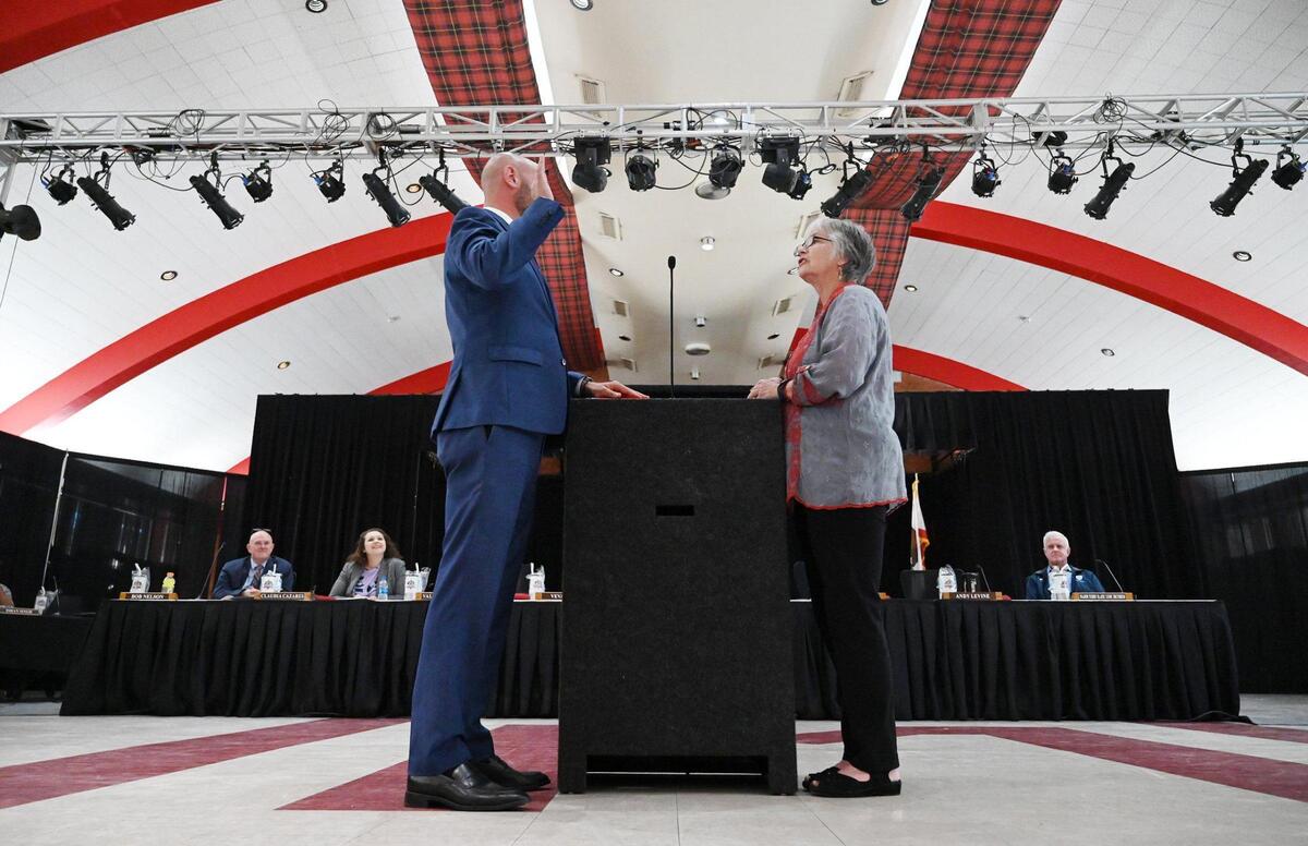 Andy Levine, left, is sworn in by his mother Trudi Thom, right, as the new Area 5 trustee on the Fresno Unified School Board in the McLane High cafeteria Wednesday afternoon, May 4, 2022 Fresno. Levine, who won in a special election in April 2022, takes the seat left by Carol Mills who passed away in July 2021.