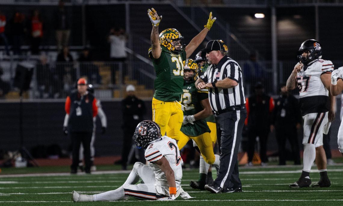 The Edison Chargers’ Matt Lopez (31) celebrates after stoping the Central Grizzlies’ Brandon Smith (2) on a fourth down play during the CIF State Division 1-A championship at Saddleback College in Mission Viejo on Saturday. The Chargers won 21-14 after scoring in the final minute.