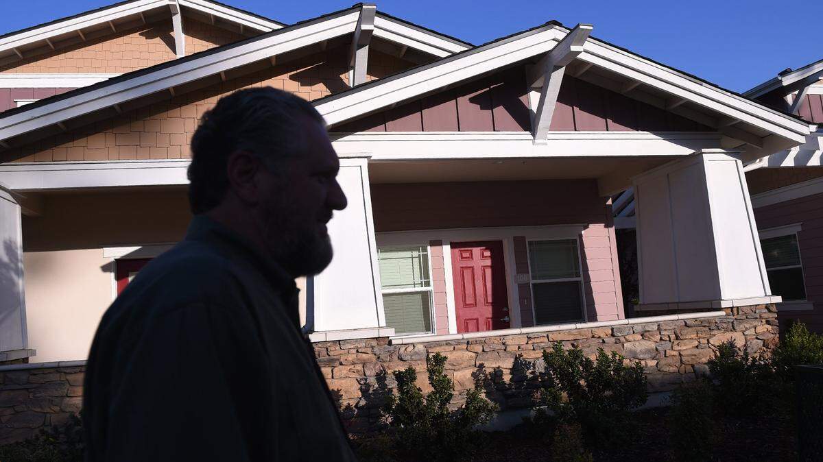 Former Fresno City Councilmember Craig Scharton, a resident of the Lowell neighborhood, walks past new affordable housing designed to match older Lowell neighborhood homes. Photographed Thursday, Nov. 7, 2019 in Fresno.