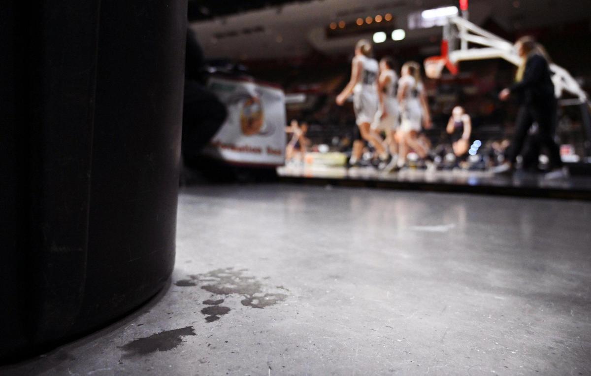 Water drops, next to a trash can where rain has been pooling on the Selland Arena court, lower left corner, is seen at the CIF Central Section basketball championships Friday, Feb. 24, 2023 in Fresno.