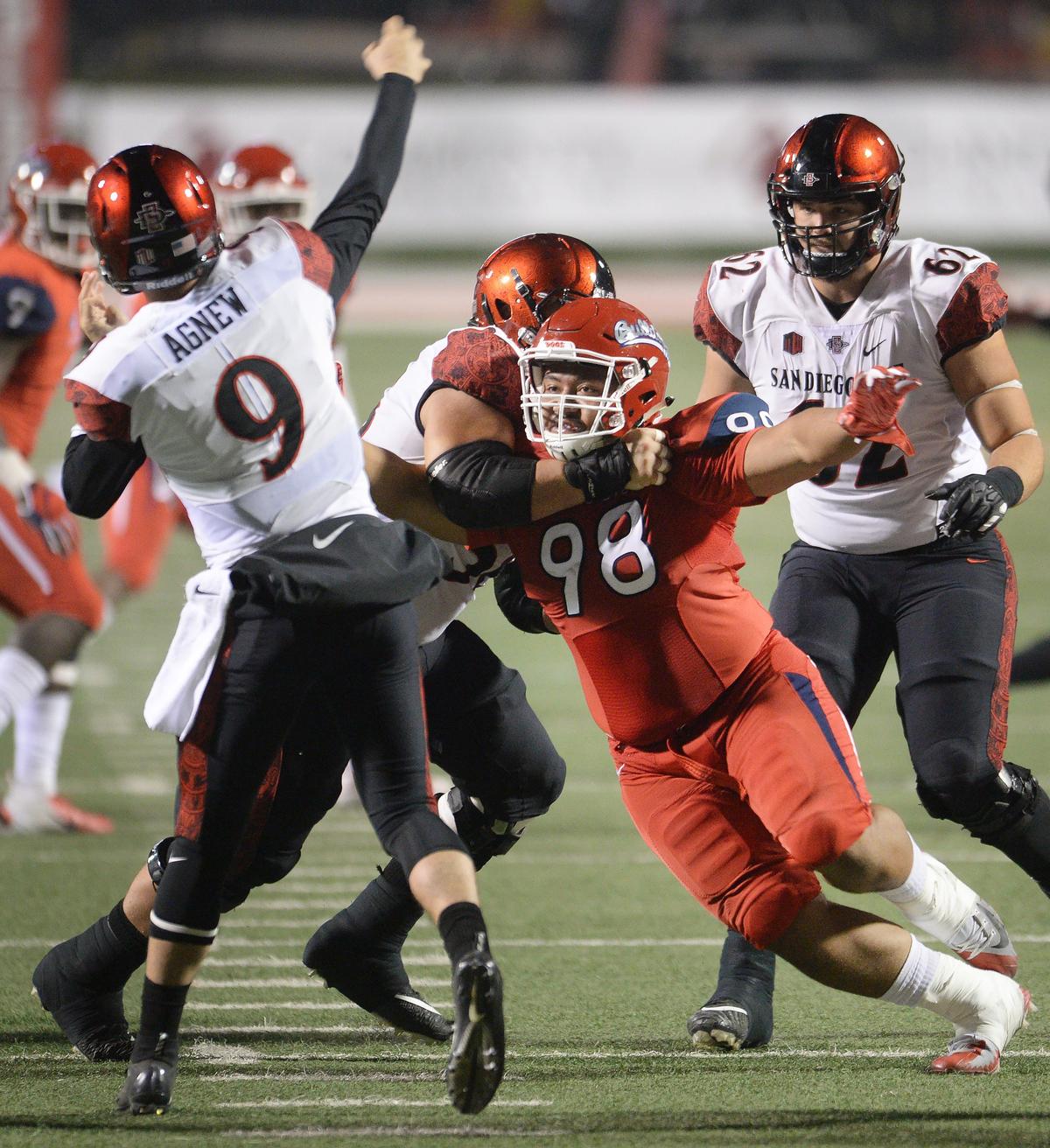 Fresno State defensive tackle Keiti Iakopo, center, puts a rush on San Diego State quarterback Ryan Agnew in the Bulldogs’ 23-14 victory over the Aztecs at Bulldog Stadium in Fresno on Saturday, Nov. 17, 2018.
