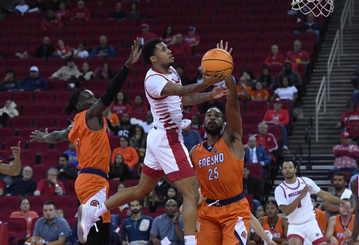 Fresno State’s Isaiah Hill, center, with Fresno Pacific’s Michael Mensah, left, and Darrin Person, Jr., right, Monday, Nov. 7, 2022 in Fresno. The Bulldogs led the Sunbirds 33-32 at halftime.