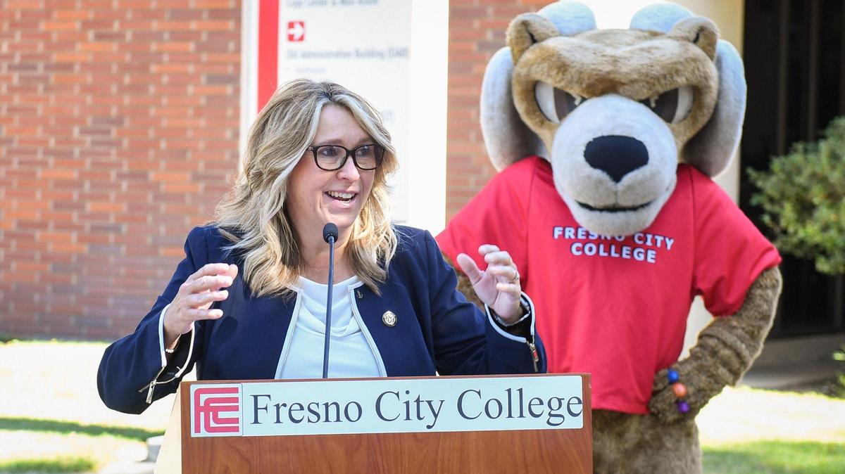 La presidenta de Fresno City College, la Dra. Carole Goldsmith, habla mientras la mascota de la escuela, Sam the Ram, está de pie en el fondo poco antes de que la bandera del Orgullo se izara en el asta de la escuela, el viernes 4 de junio de 2021. La Junta Directiva del State Center Community College District aprobó el martes una resolución que reconoce junio como el Mes del Orgullo, lo que llevó al izado de la bandera el viernes.