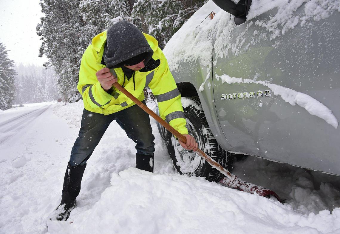 Skyler Burks helps a friend’s son stuck in snow along Highway 168 just outside of Shaver Lake as snow falls Wednesday, Nov. 27, 2019.