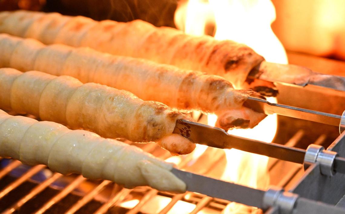 Beef in a blanket and cheese in a blanket are grilled over a flame at the new Cheesy Bread House located in the same shopping center as Costco on West Shaw Avenue. Photographed Friday, June 23, 2023.