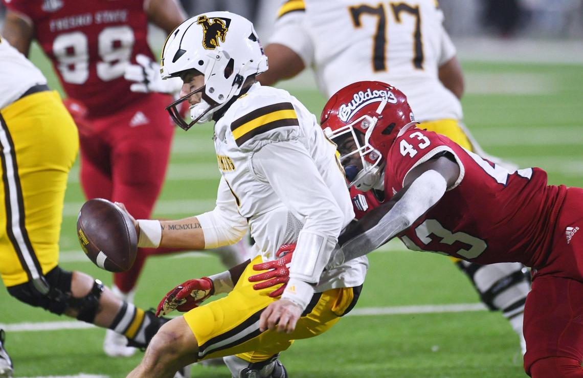 Fresno State’s Morice Norris Jr., right, sacks Wyoming quarterback Andrew Peasley in game action Friday, Nov. 25, 2022 in Fresno. The Bulldogs led 23-0 at halftime.