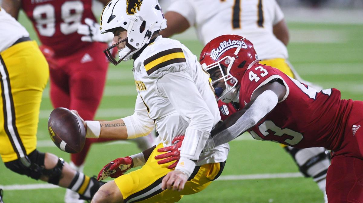 Fresno State’s Morice Norris Jr., right, sacks Wyoming quarterback Andrew Peasley in game action Friday, Nov. 25, 2022 in Fresno.