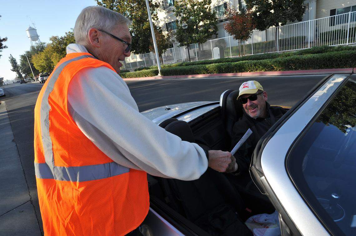 Dwight Kroll, city of Clovis director of planning and development, turns in his ballot to elections clerk Ken Warkentin outside the Clovis Veterans Memorial District building Tuesday morning.