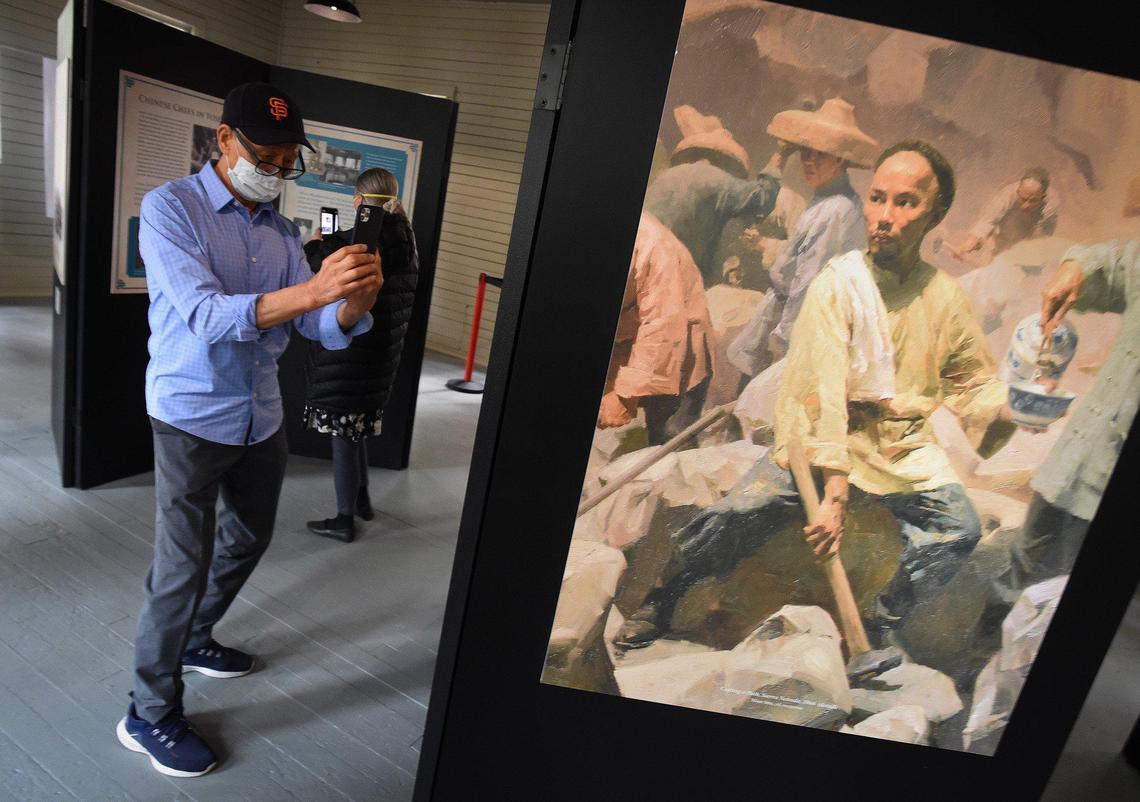 Ed Hung of San Francisco takes a photo of a Chinese laborer in an exhibit in the restored 1917 Chinese laundry building, after its dedication at Wawona, Friday, Oct. 1, 2021. The building was used as various things over the years and is being rededicated to tell the story of Chinese American contributions to Yosemite’s history.