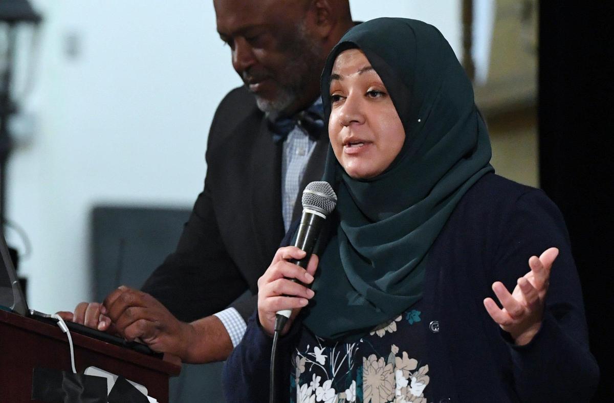 Sukaina Hussain from CAIR California, right, addresses the crowd with Dr. Darren Miller seen in the background at the Stop The Hate Town Hall held at Central East High School campus Wednesday night, Jan. 25, 2023 in Fresno. Organized by Community Alliance newspaper, the town hall is the second of three planned events designed to address the growing problem of hate crimes.