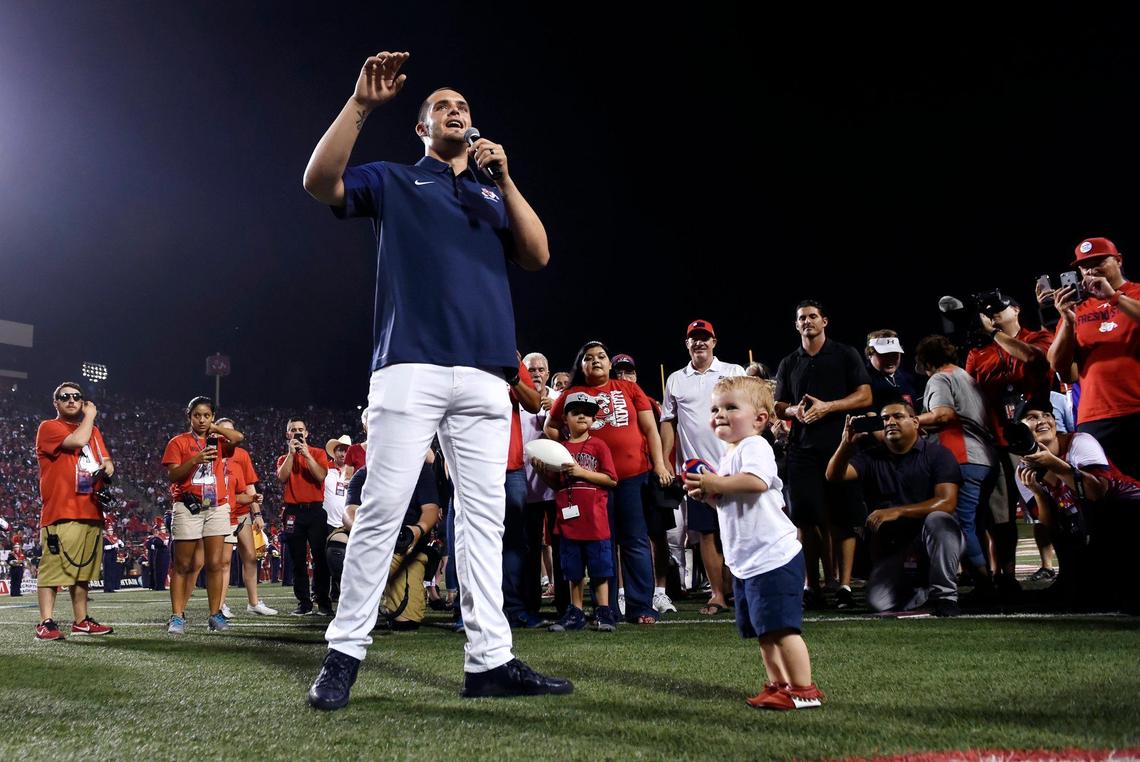 Former Fresno State quarterback Derek Carr, with his youngest son Deker Luke Carr, to the right, addresses the crowd during the halftime ceremony where is jersey was retired during the Bulldogs' season home opener Saturday, Sept. 2, 2017 in Fresno. The ceremony and game against Incarnate Word drew 39,447, the largest crowd of the season at Bulldog Stadium.