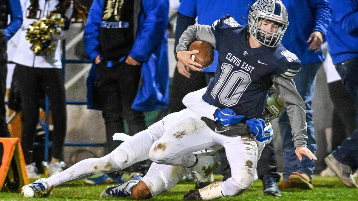 Clovis East quarterback Tyus Miller gets pulled down after scrambling for a first down against Clovis during their Central Section Division 1-AA semifinal game at Lamonica Stadium in Clovis on Friday, Nov. 15, 2024.