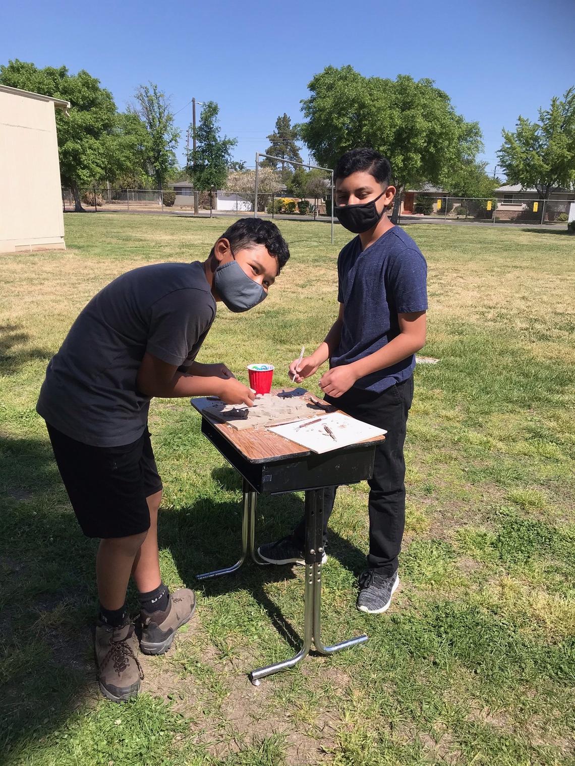 Manchester GATE sixth grade students work on their porcelain-mix ceramic leaves to be added to the valley oak mural being put together by Fresno artist David Roberts.