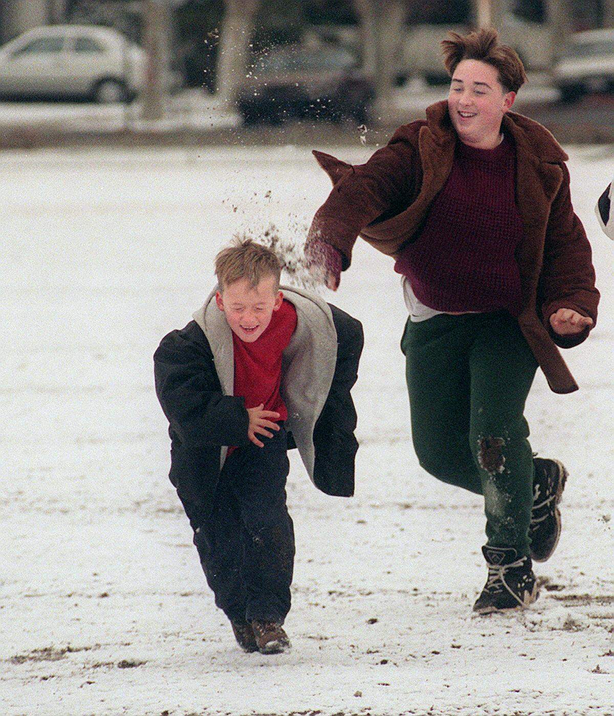 Matthew Sawyer, 7, takes a direct hit with a snowball from his brother James Sawyer, 13, at the snow-covered baseball field at Fresno High School on Monday Dec. 21, 1998.