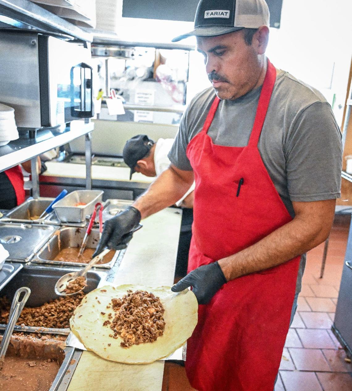 Rene Gallegos prepares a burrito order at Adrian’s on Monday, June 24, 2024.