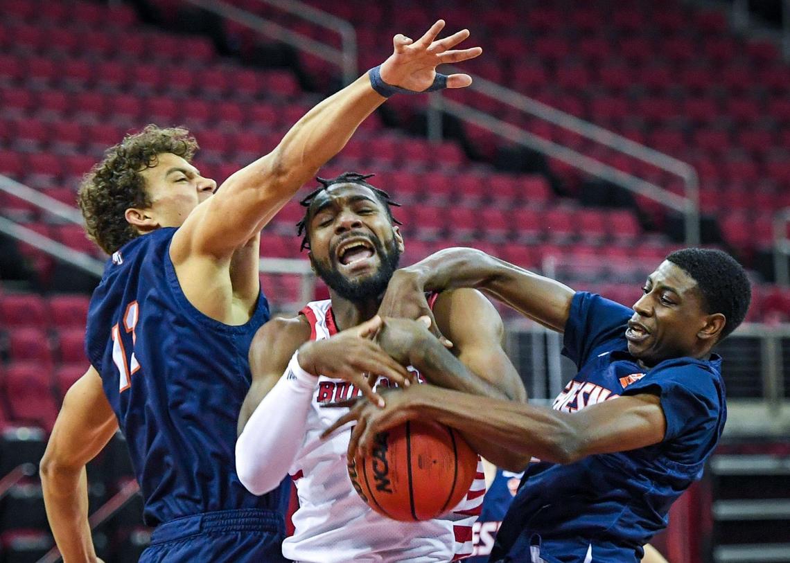 Fresno State’s Jordan Campbell, center, tries to go to the hoop but is fouled by Fresno Pacific’s Jamal Briscoe, right, as teammate Sean Nealon-Lino defends in the first half of their game at the Save Mart Center in Fresno on Saturday, Dec. 19, 2020.