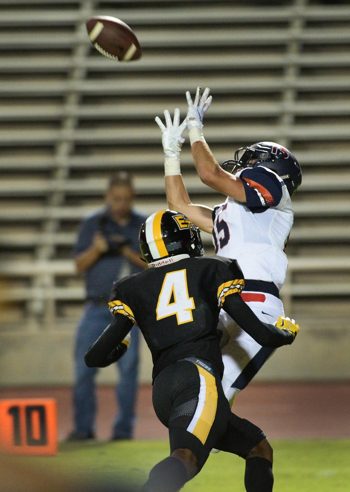 Memorial’s Mac Dalena, top, reaches up for a pass completion near the goal line with Edison’s Dezjhon Malone defending during their game at Ratcliffe Stadium in Fresno on Friday, Oct. 12, 2018.
