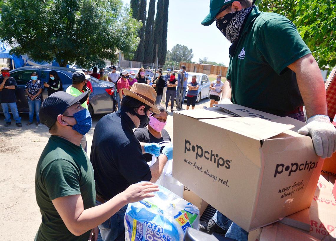 Two volunteers from Education & Leadership Foundation help unload essentials for distribution to farmworkers Saturday afternoon, May 9, 2020 near Rolinda, CA.