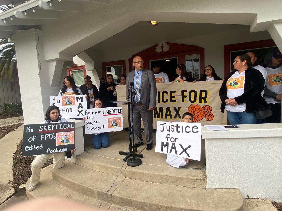 Family members and supporters surround attorney Kevin Little on Friday, Jan. 12, 2024, holding signs during a news conference in downtown Fresno in which the decried the fatal shooting of Maximiliano “Max” Sosa Jr., 33, by Fresno police on Nov. 4, 2023.