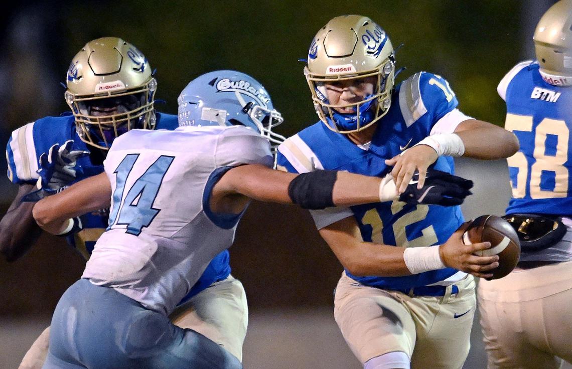 Clovis High quarterback Deagan Rose, center, runs the ball with Bullard’s Brayden Chiarito to the left Friday night, Sept. 20, 2024 at Lamonica Stadium in Clovis.
