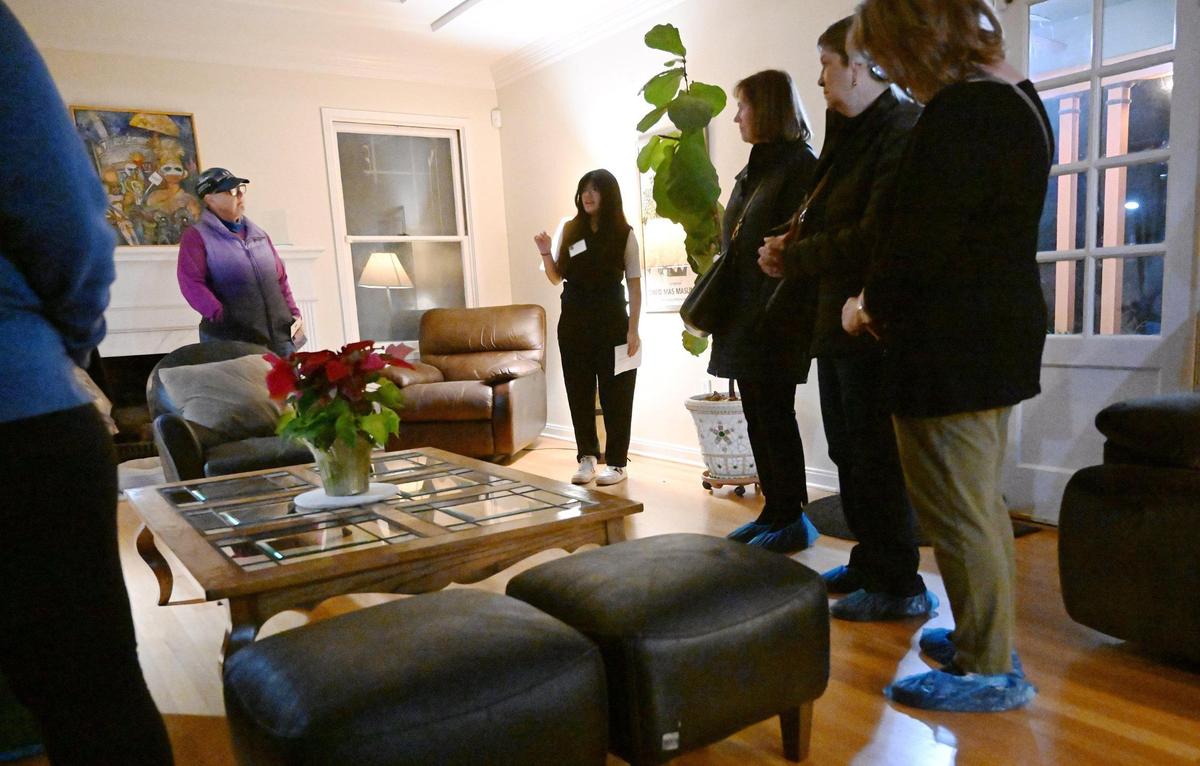 A Fresno High student, background, describes a living room during the 2024 Fresno High Neighborhood Holiday Home Tour Monday evening, Dec. 2, 2024.