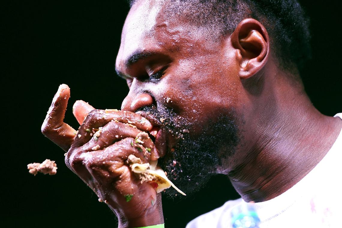 Gideon Oji shoves a taco into his mouth at the Taco Truck Throwdown 8 taco-eating contest Friday night, July 20, 2018 in Fresno.