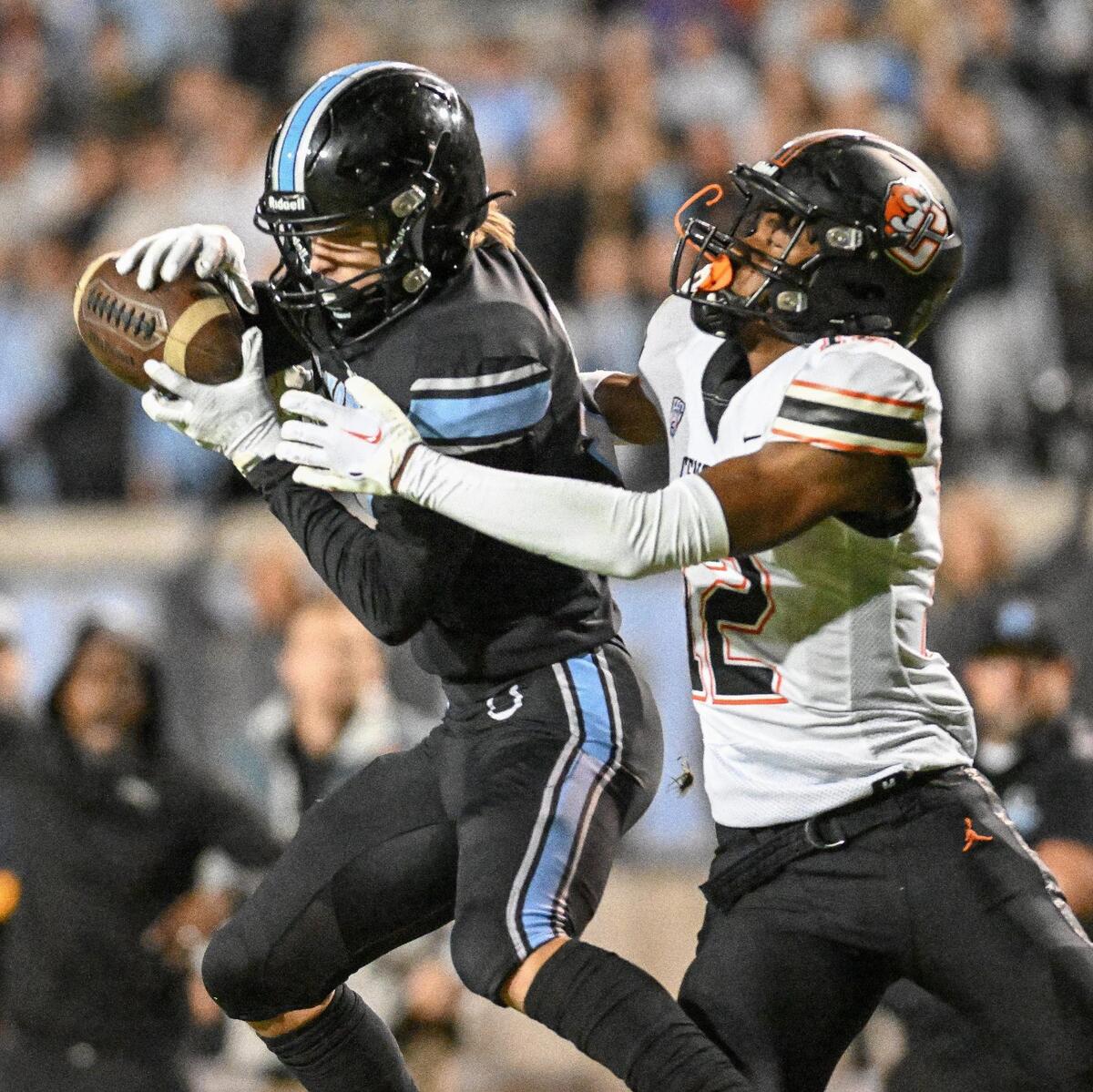 Clovis North’s Trent Rogers, left, intercepts the ball in front of Central receiver Noel Felix III in the first half of their Central Section Division 1 football championship game at Veterans Memorial Stadium in Clovis on Friday, Nov. 24, 2023.