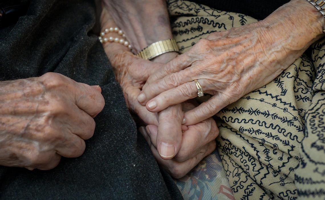 Malcolm and LaVerne Masten hold hands together in their apartment at the Terraces at San Joaquin Gardens in Fresno on Monday, Oct. 21, 2019. The couple, married 76 years, both celebrated turning 100 this year.
