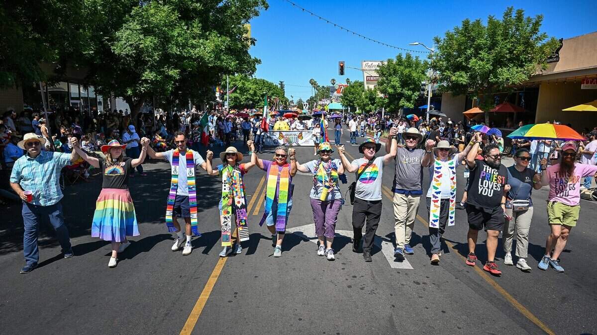 Local faith leaders from various area churches hold hands while walking down Olive Avenue during the annual Fresno Rainbow Pride Parade and Festival in the Tower District on Saturday, June 6, 2026.