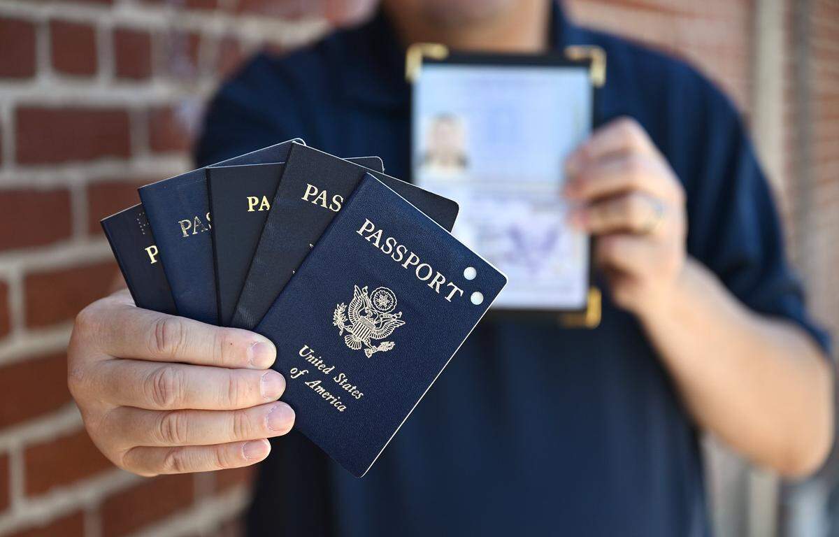 Paul Liu, who recently renewed his US passport, holds a collection of passports he's held over the years. This is the first time he's renewed not for travel but for proof of citizenship, he added. Some Californians are carrying their US passsports to avoid ICE profiling and reduce fear of deportation. Photographed Thursday, July 30, 2025 in downtown Fresno.