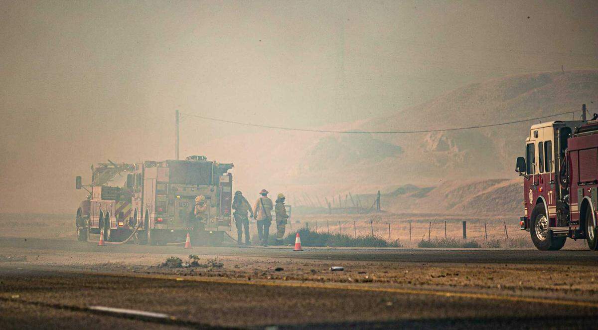 Thick smoke and temperatures still in excess of 100 degrees greeted firefighters battling a 125-acre grass fire off Friant Road in Fresno County, California on Sunday, June 27, 2021.