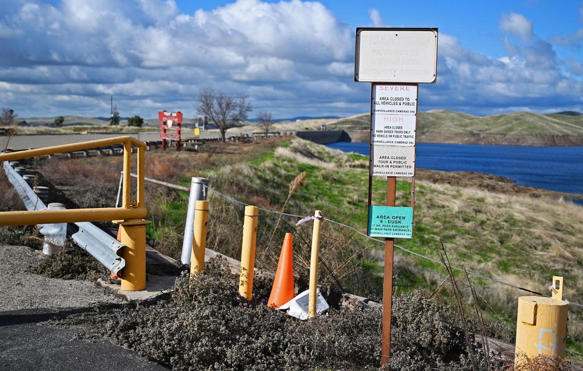 Weather-faded security signs are seen at the locked gate to the parking lot near the top of Friant Dam at Millerton Lake. Photographed Tuesday, Jan. 23, 2024 near Friant, California.