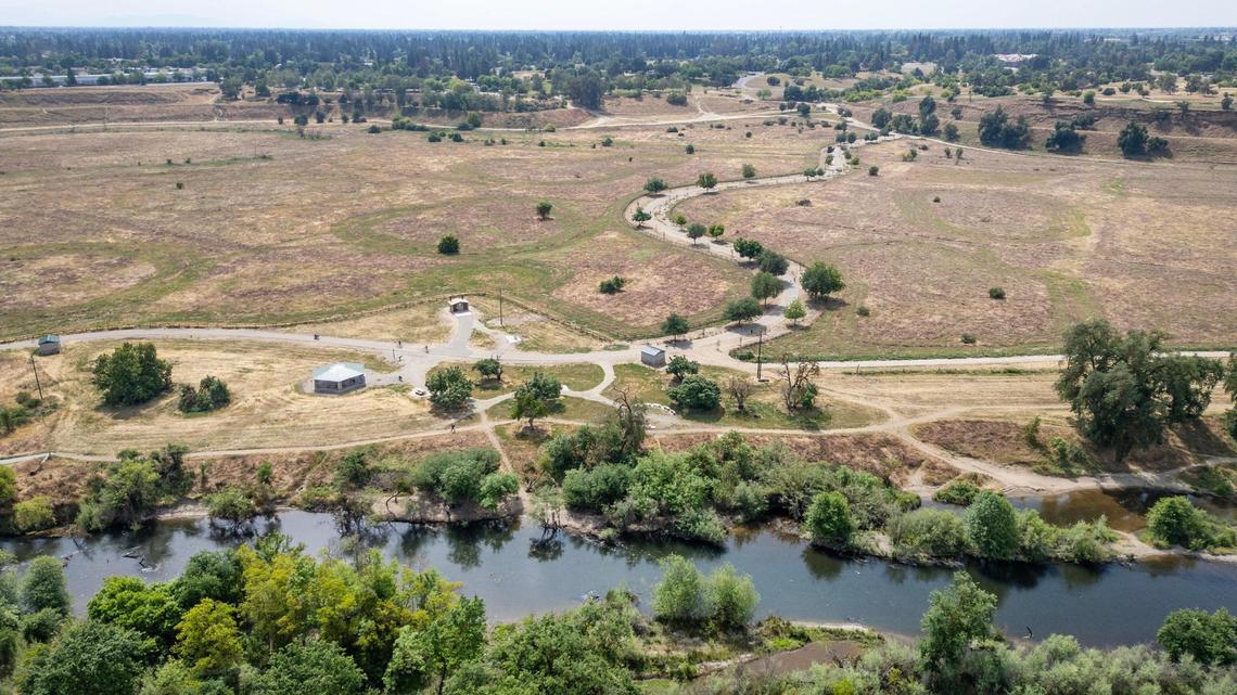 A river access trail in the Jensen River Ranch area, part of the San Joaquin River Conservancy, leads to the San Joaquin River flowing just to the north of Fresno’s Woodward Park, background, in this drone image taken on Wednesday, April 20, 2025.
