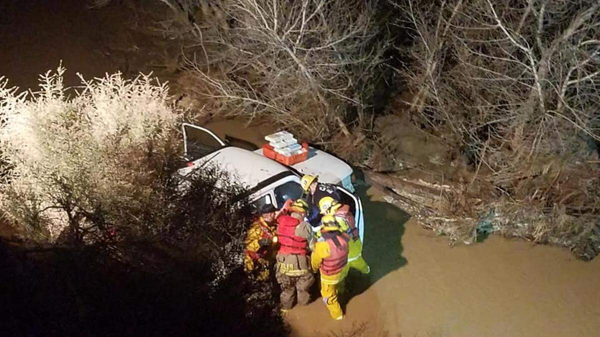 Firefighters rescue two people trapped in an SUV that went down an embankment in Coalinga, Calif. on Saturday, Feb. 16, 2019.