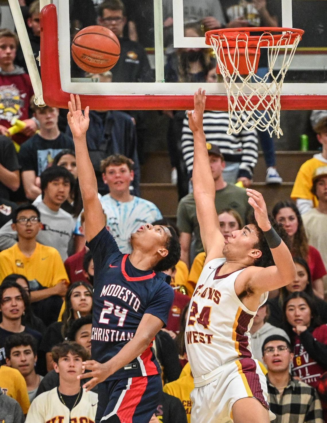 Clovis West’s Tyus Parrish-Tillman, right, tries to defend a reverse layup by Modesto Christian’s Jamari Phillips during their NorCal Open Division boys basketball semifinal at Clovis West on Saturday, March 5, 2022.