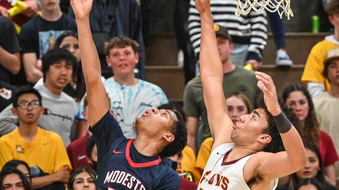 Clovis West’s Tyus Parrish-Tillman, right, tries to defend a reverse layup by Modesto Christian’s Jamari Phillips during their NorCal Open Division boys basketball semifinal at Clovis West on Saturday, March 5, 2022.