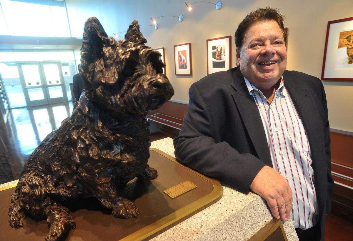 David McDonald, with the bronze sculpture of his beloved Miss Winkles, by Lorne McKean of England, in the lobby of the Miss Winkles Pet Adoption Center --