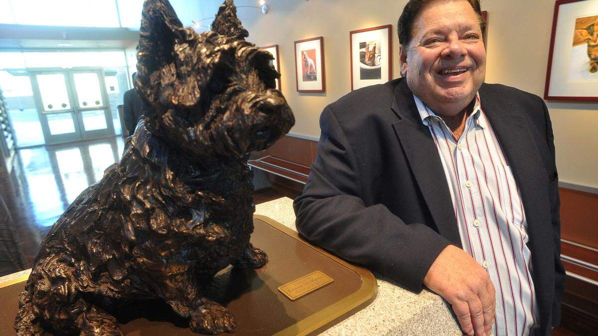 David McDonald, with the bronze sculpture of his beloved Miss Winkles, by Lorne McKean of England, in the lobby of the Miss Winkles Pet Adoption Center --