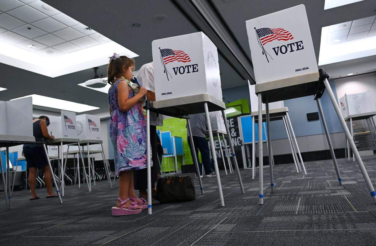 Amelia Palmore, 5, waits as her grandmother Nida Palmore votes at the DBH Health and Wellness Center voting center on Tuesday, June 7, 2022 in Fresno.