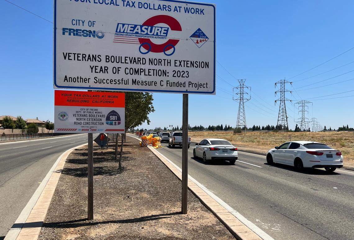 Signs on busy Herndon Avenue east of Hayes Avenue proclaim the near-completion of Veterans Boulevard in northwest Fresno on Aug. 7, 2023. Eastbound Herndon is now closed between Hayes and Polk avenues, and traffic equipment is diverting drivers to a new route on a portion of Veterans Boulevard.