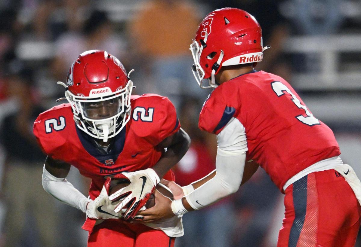 Sanger’s Carlos Young, left receives the handoff against Dinuba in the second half Friday, Aug. 18, 2023 in Sanger. Final score, Sanger 41, Dinuba 7.