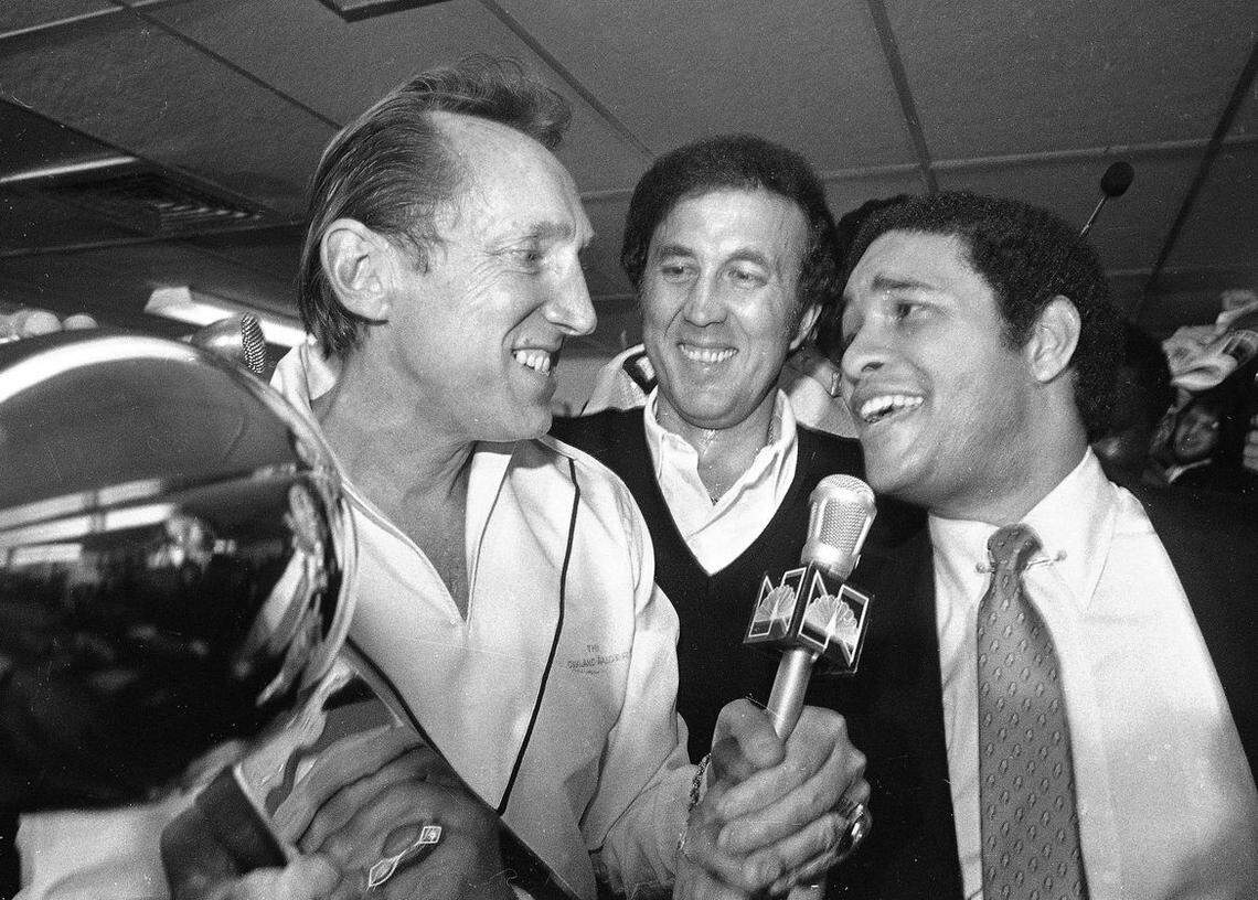 In this Jan. 25, 1981, file photo, Oakland Raiders managing general partner Al Davis, left, talks with sportscaster Bryant Gumbel, right, after receiving the Super Bowl XV trophy as Raiders head coach Tom Flores, center, looks on in New Orleans.