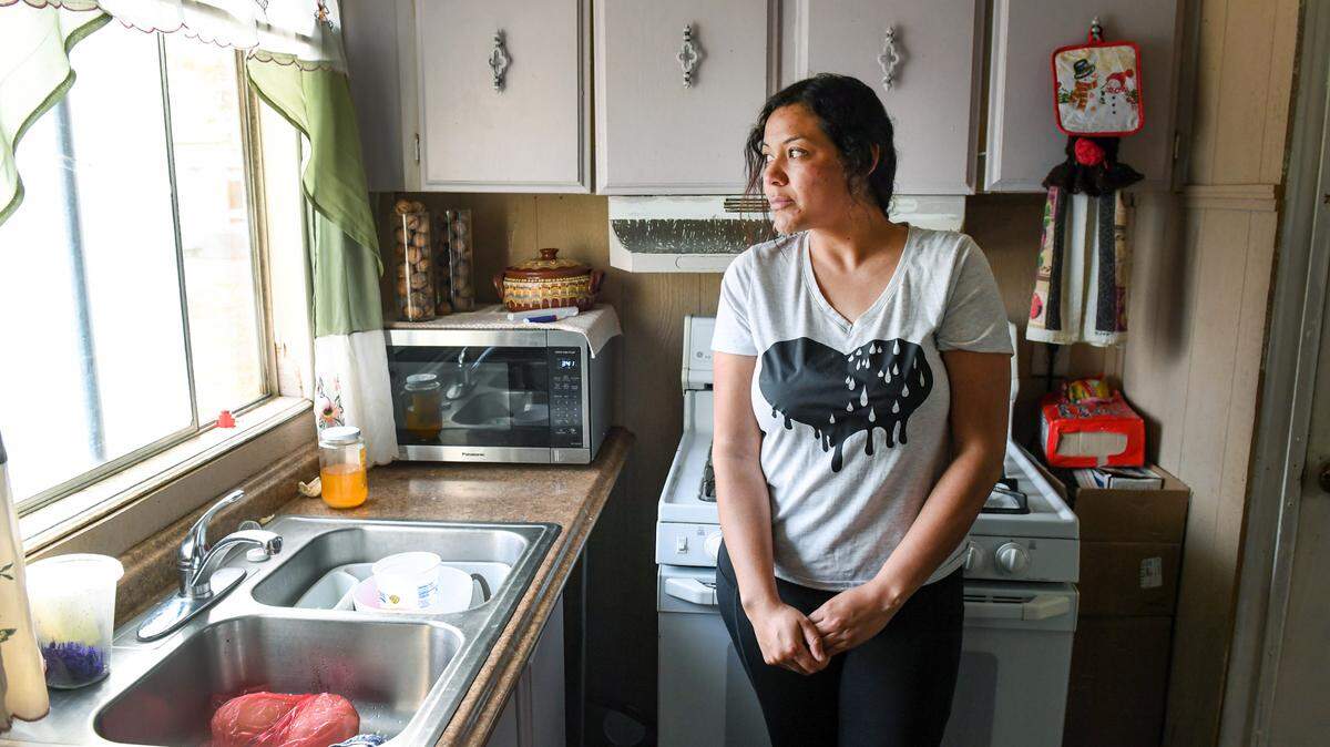 Carolina, 34, stands in the kitchen of her mobile home in rural Fresno County on Tuesday, March 2, 2021. She asked that her last name not be published because she feared possible repercussions for her family.