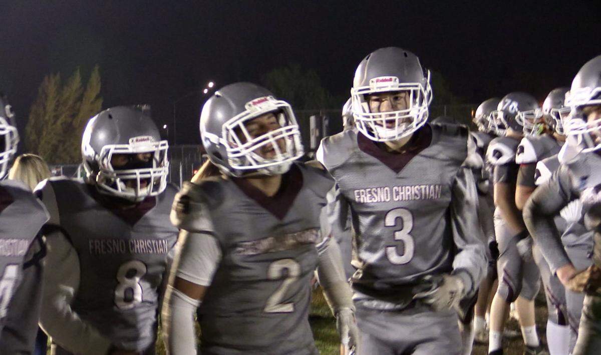 Paul Sheppard, middle, is congratulated by teammates after a game-clinching interception in the fourth quarter. Fresno Christian defeated Sierra 30-27 for the Central Section eight-man championship on Friday, Nov. 18, 2022.
