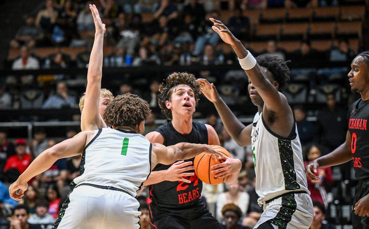 Buchanan's Luke DeManby, center, gets trapped among St. Joseph players while trying to go for a layup during their Central Section Division 1 boys basketball championship game at Selland Arena on Saturday, Feb. 28, 2026.